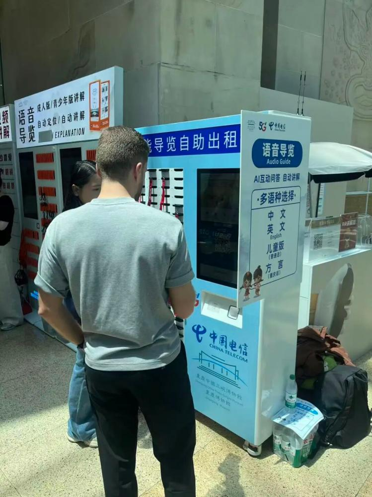观众在三峡博物馆自助出租柜前租用导览机